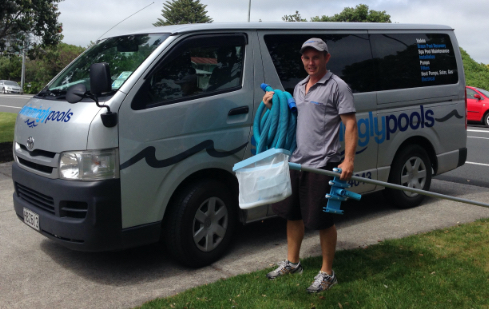 guy holding pool cleaning equipment-pool maintenance services-Swimmingly Pools